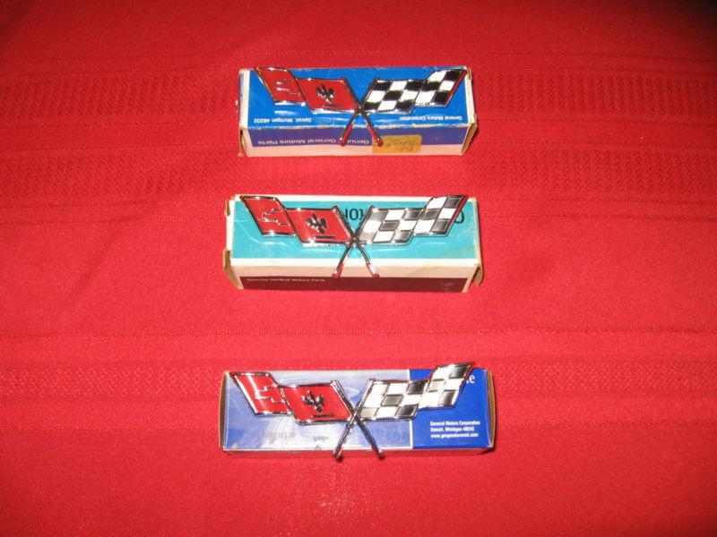 Three genuine gm 1977 to 1979 corvette cross flags emblems, still in box