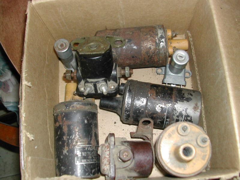 A box of used ignition coils dimmer switches and starter seloninod