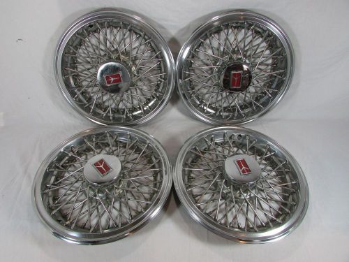 Set of (4) matching vintage oldsmobile 14&#034; wire spoke hub caps~oem wheel covers