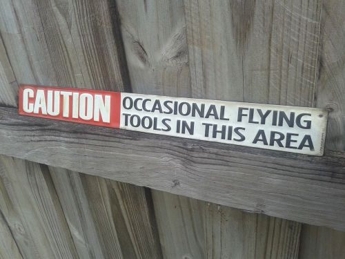 Caution occasional flying tools metal sign with raised letters 18 by 2 inches