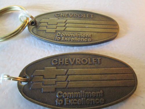 Two vintage chevrolet-commitment-to-excellence-brass-key-ring-fob-deposit-in-mai