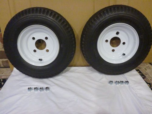 Two golf cart wheels and tires with nuts