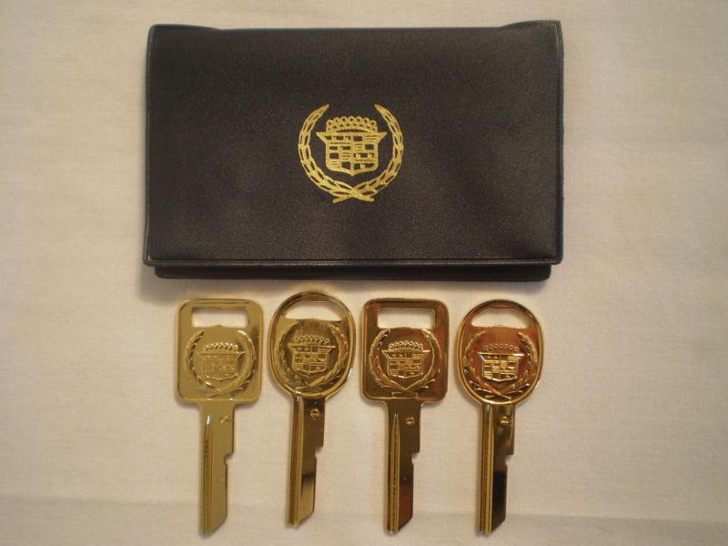 (4) cadillac gold-plated unused/uncut/blank c/d car key set w/ plastic carrier