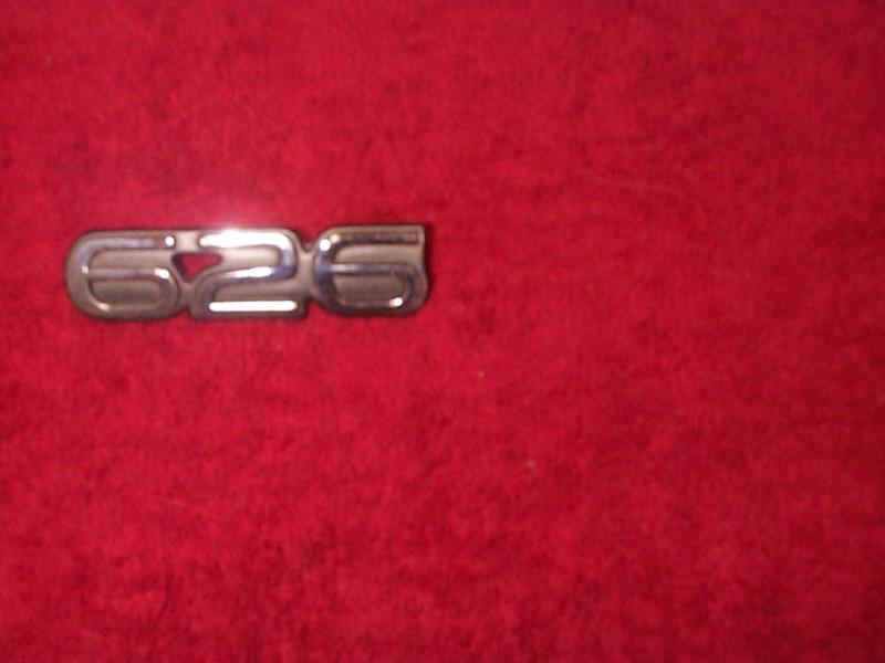 Factory mazda 626 emblem rear trunk badge silver on black 3 3/8 wide 7/8 tall